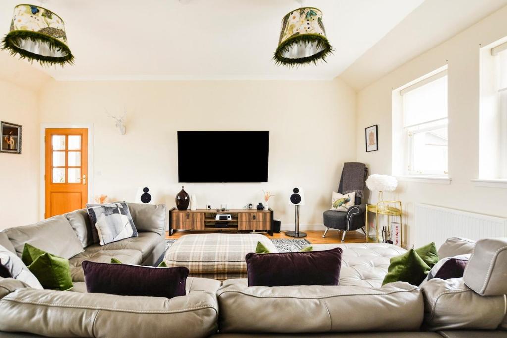 a living room with a couch and a flat screen tv at Luxury Seaview Gated Penthouse located near Edinburgh in Kirkcaldy