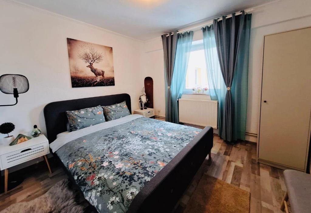 a bedroom with a large bed with blue curtains at Hellen Studio Predeal in Predeal