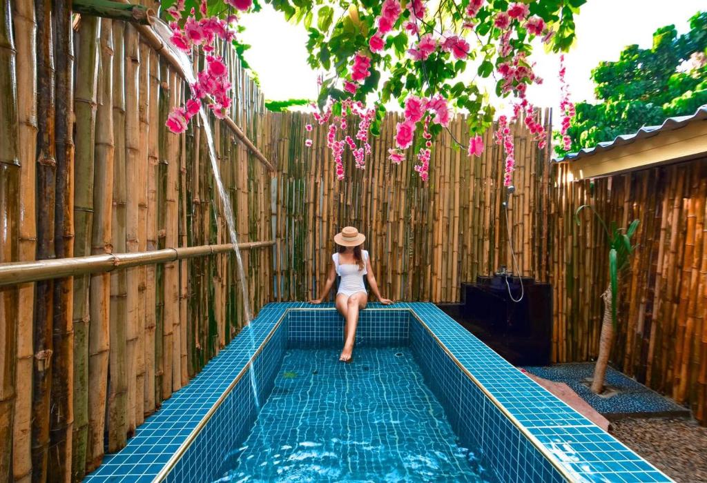 a woman sitting on the edge of a swimming pool at Tani Ryu River Kwai in Ban Tha Pong (1)