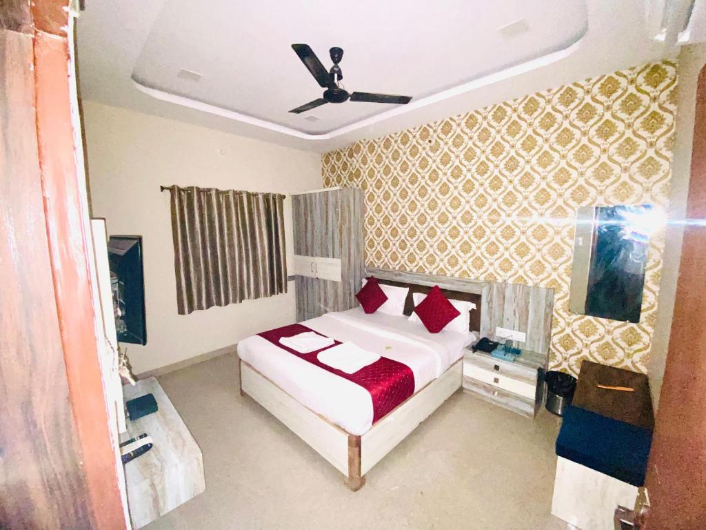 a bedroom with a bed with red pillows at Vinayak shree hotel in Indore