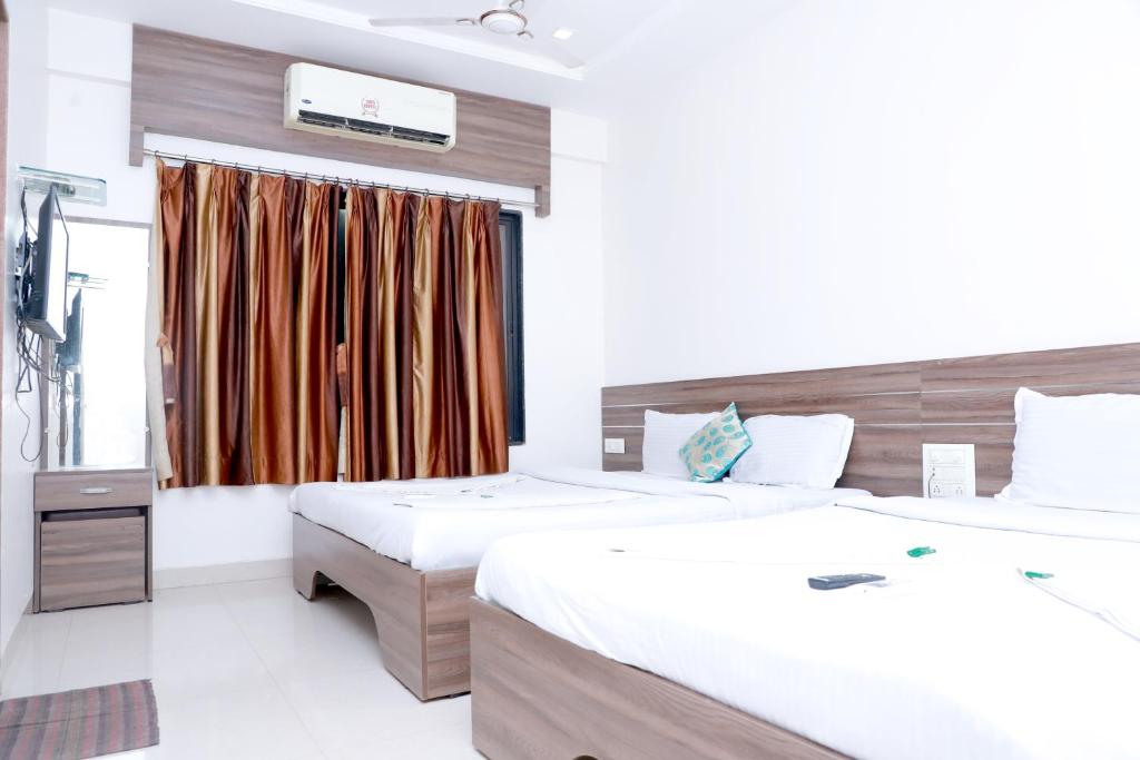 Postel nebo postele na pokoji v ubytování Hotel Matoshree