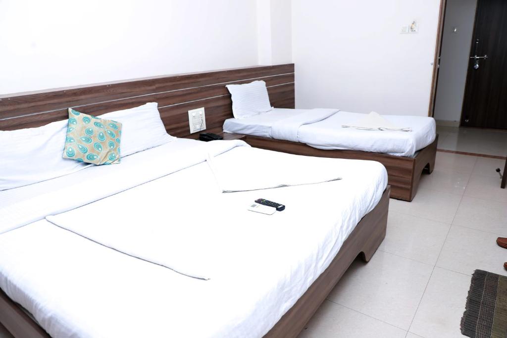 Postel nebo postele na pokoji v ubytování Hotel Matoshree