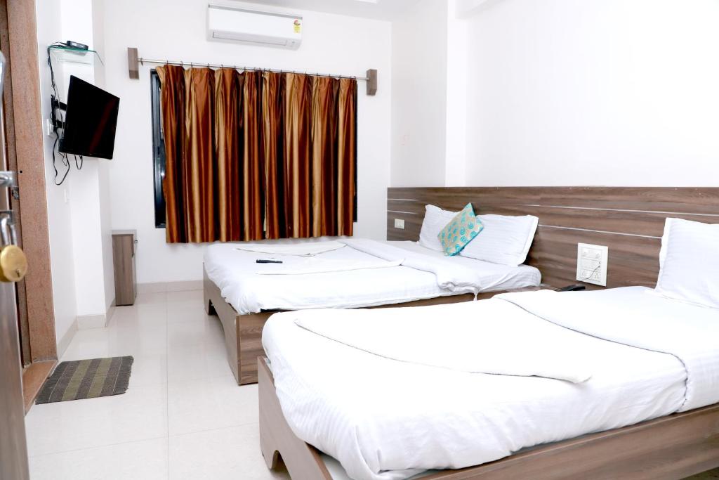 Postel nebo postele na pokoji v ubytování Hotel Matoshree