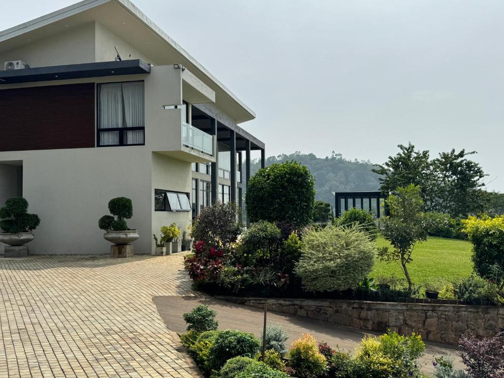 a white house with a brick driveway and plants at Moragolla Estate Bungalow Kothmale in Gampola