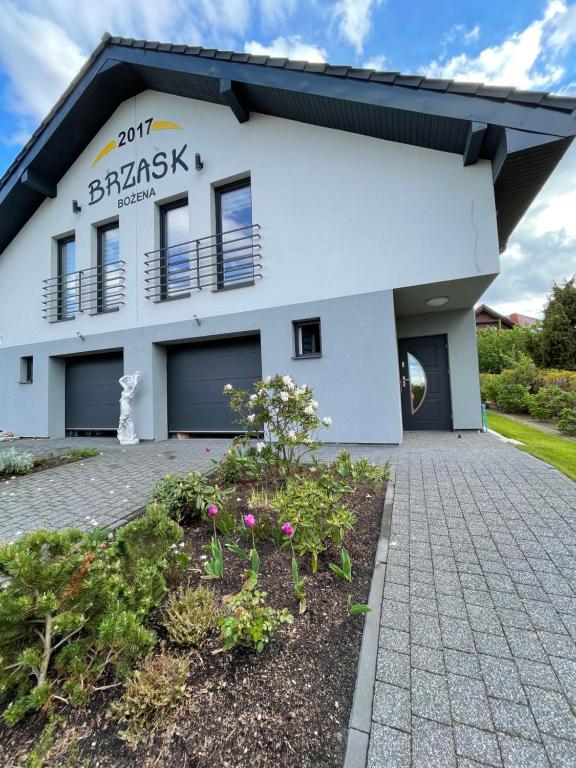 Biały budynek z podjazdem przed nim w obiekcie Brzask w mieście Mosty