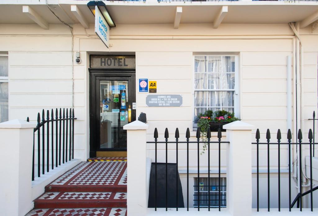 une maison blanche avec une porte noire et une clôture dans l'établissement Dover Hotel - B&B, à Londres