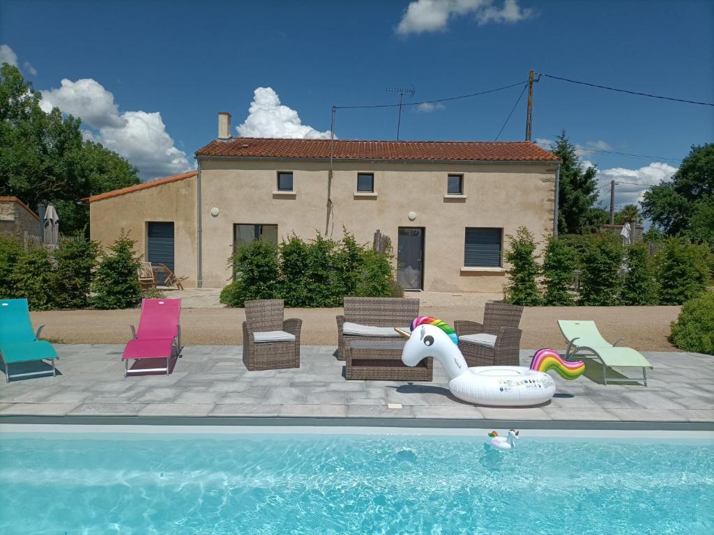 - une piscine avec un flotteur gonflable d'orgue à côté d'une maison dans l'établissement Gîte pOm de Reinette, aux Herbiers