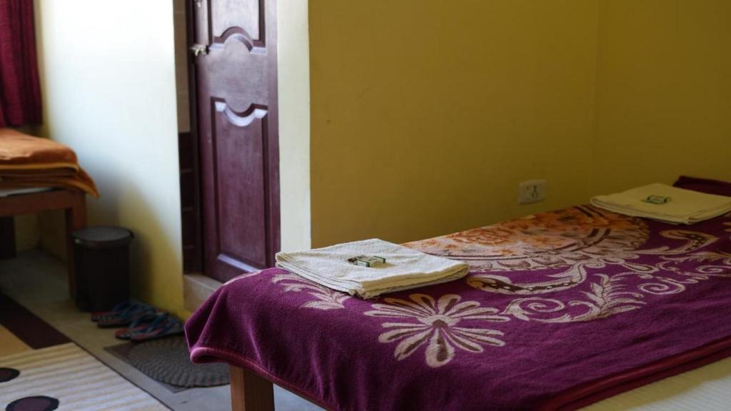 Postel nebo postele na pokoji v ubytování Satya Anand Cottage Pure Veg and Non Alcoholic Hotel