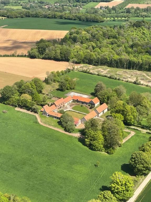 une vue aérienne d'une grande maison dans un champ dans l'établissement La Ferme de la Forêt, gite de groupe à la campagne, à Longvilliers