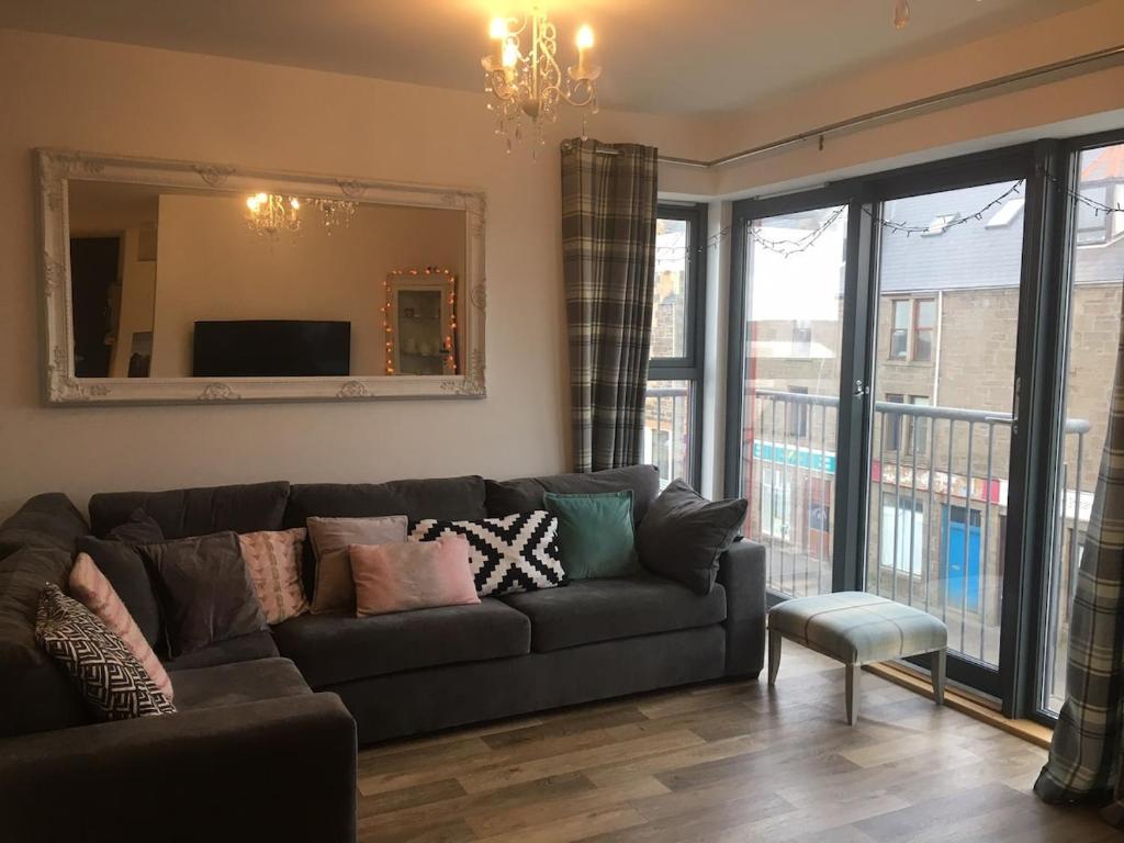 ラーウィックにあるStunning 1 Bedroom Lerwick Town Centre Apartmentのソファと鏡のあるリビングルーム