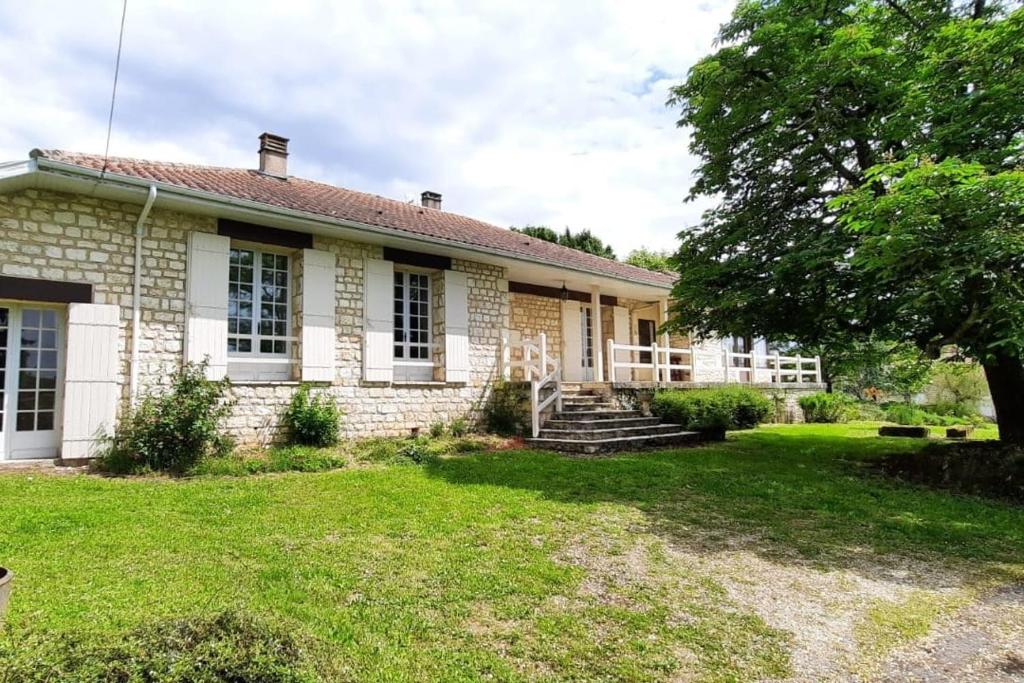 une vieille maison en briques avec un arbre dans la cour dans l'établissement Monpazier Country House in Périgord, à Gaugeac