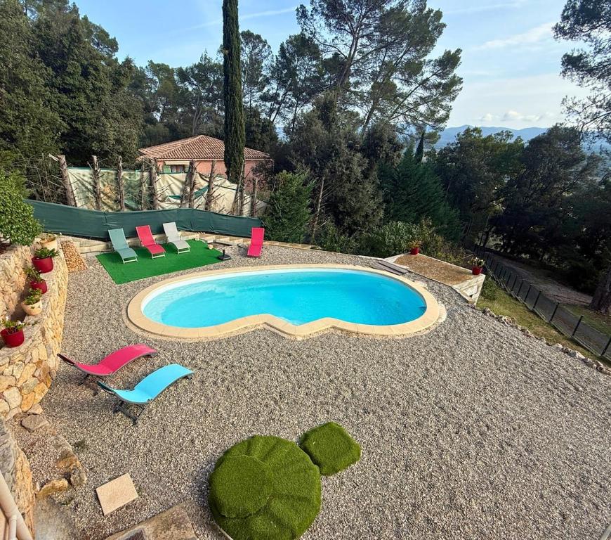 - une piscine dans un jardin avec des chaises longues et un salon dans l'établissement Villa avec Piscine privée - La Sauvageonne, à Vidauban