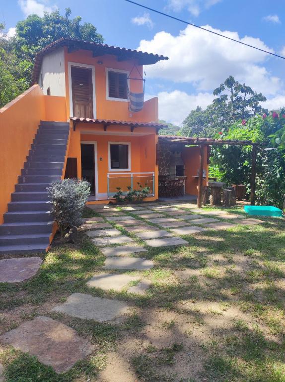 an orange house with stairs leading to a yard at Aconchego do Áureo in Pacoti