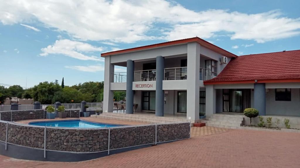 a building with a pool in front of it at On Hill Lodge in Bloemfontein