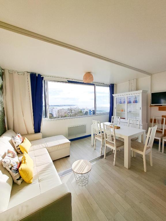 salon z kanapą i stołem w obiekcie L'escale - VUE MER, PLAGE, CENTRE VILLE, IDÉAL POUR COUPLE w mieście Royan