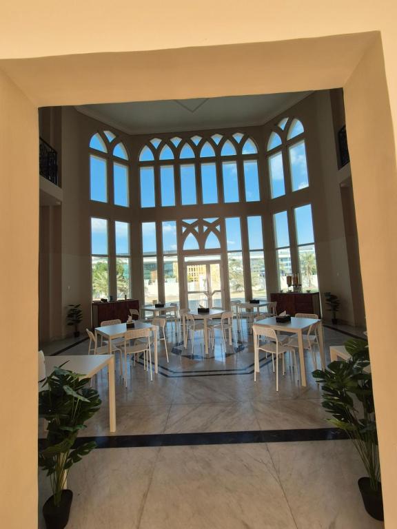 a group of tables and chairs in a room with windows at Four Stars Residence in Dubai