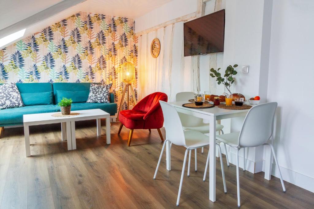 a living room with a couch and a table and chairs at La Mansarde Cauchoise - Centre ville - Au calme in Rouen