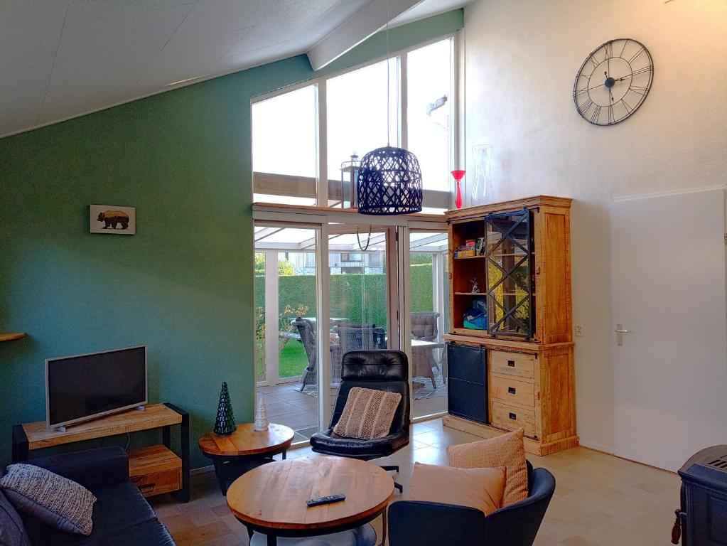 a living room with a couch and a table at Vakantiewoning met serre en airconditioning in Tzummarum