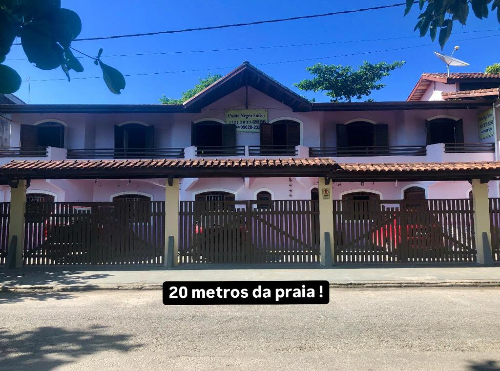 a building with a fence in front of it at Pousada Stilo Ponta Negra in Ubatuba