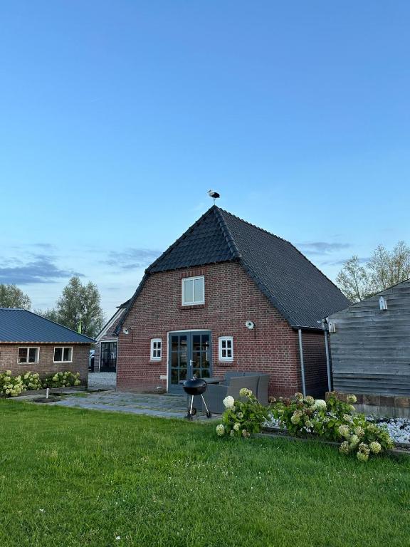 a red brick house with a grill in the yard at Huisje over de IJssel in Zwolle