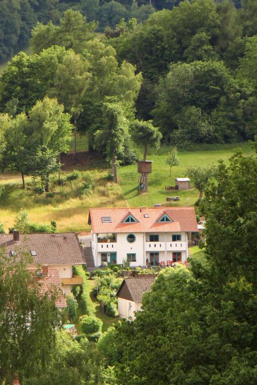 a large white building with red roofs in a village at Ferienwohnung-am-Kühl in Poppenhausen
