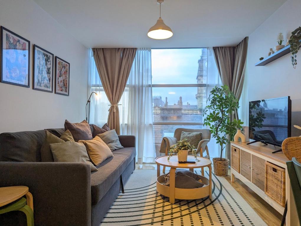 a living room with a couch and a tv and a table at City Centre Morden 1-bedroom Apt Near Dock in Liverpool