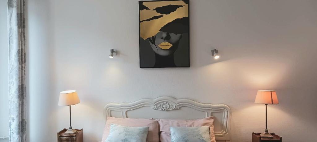 une chambre avec un lit et un tableau au mur dans l'établissement Jolie maison avec jardin clos - Fontainebleau Héricy, 35 min Paris, à Héricy