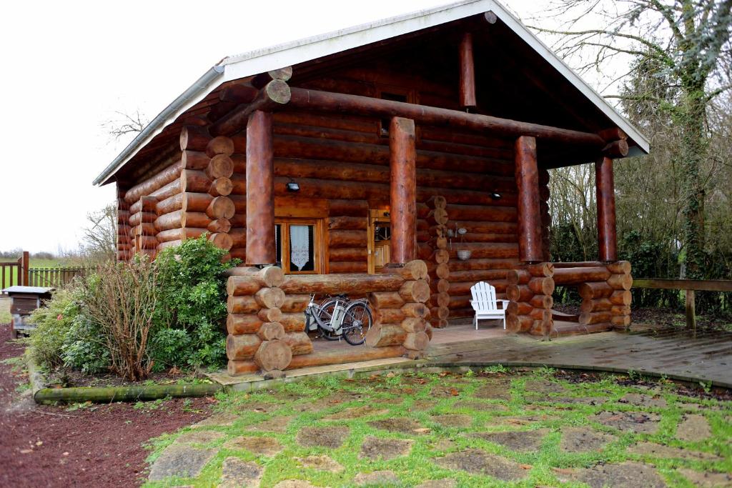 a log cabin with a bike in front of it at Gite En Rondins in Janvry