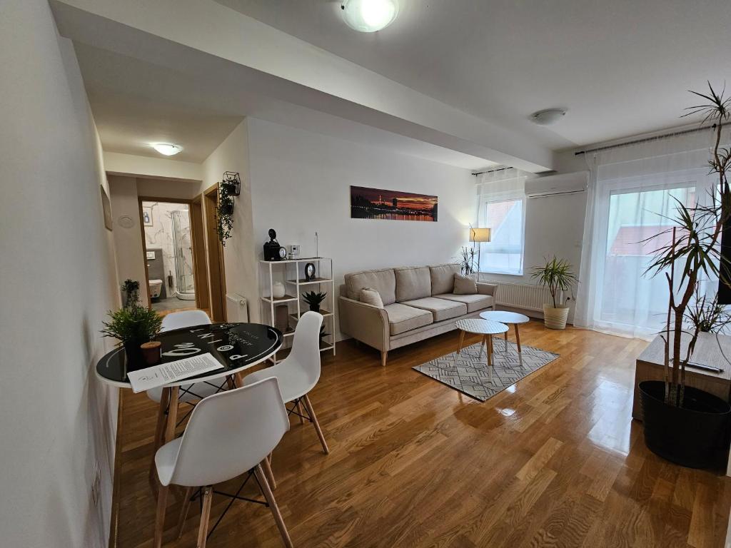 a living room with a couch and a table and chairs at OnPoint Apartmani in Osijek
