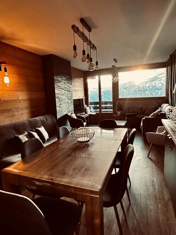 un salon avec une table et des chaises en bois dans l'établissement Pra Loup 1600, à Uvernet