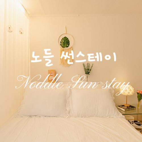 a bedroom with a bed with a sign on the wall at Noddle Sun Stay in Seoul