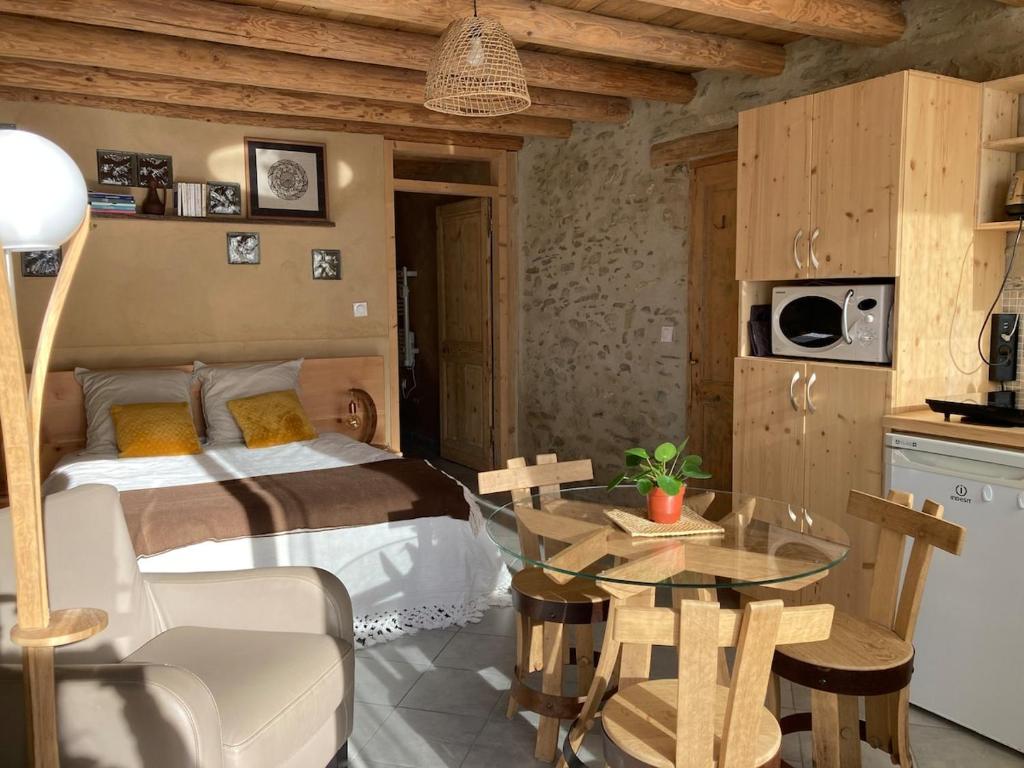 une chambre avec un lit et une table en verre dans l'établissement Les 5 Crêts - Studio en Montagne, à Saint-Pierre-dʼAllevard