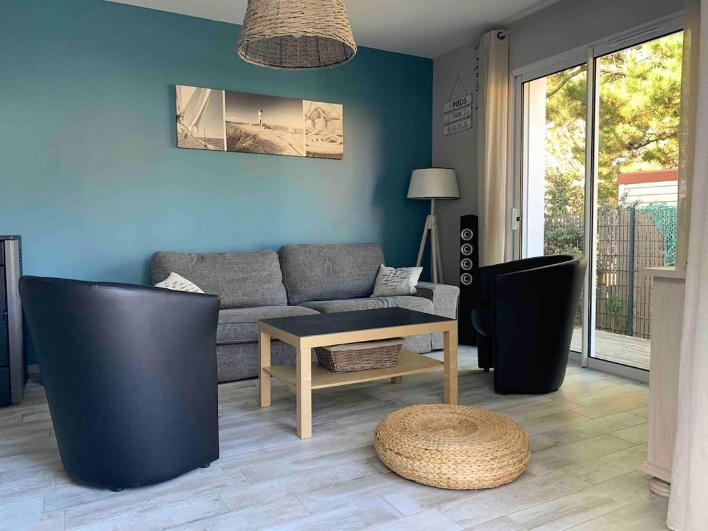 un salon avec un canapé et une table dans l'établissement Maison les pieds dans le sable 350m de la mer vélos, à Bretignolles-sur-Mer
