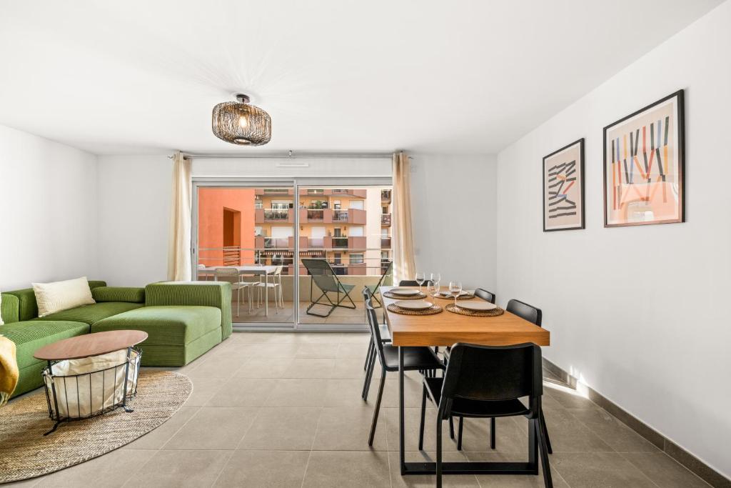 - un salon avec une table et un canapé vert dans l'établissement Val d'Or, appartement moderne et famillial pour 4 personnes, Parking, centre gare, à Menton