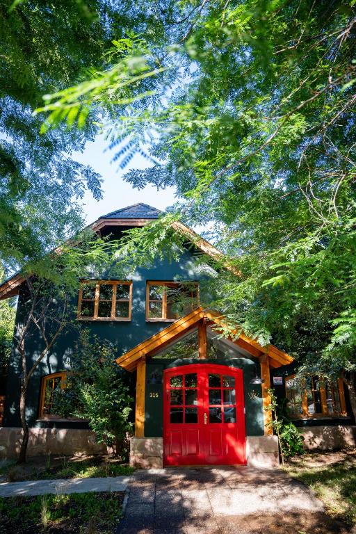 a house with a red door in front of it at Warthon Hostel in San Martín de los Andes