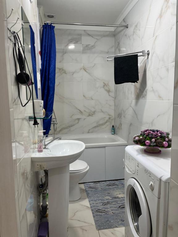 a bathroom with a toilet sink and a washing machine at Elisavetinskaya 15 in Odesa
