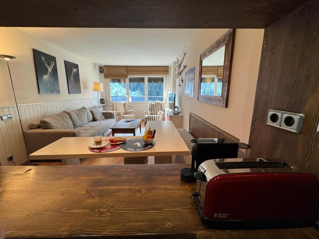 a living room with a table and a couch at Baqueira1500, apartamento con vistas a pie de pistas in Naut Aran