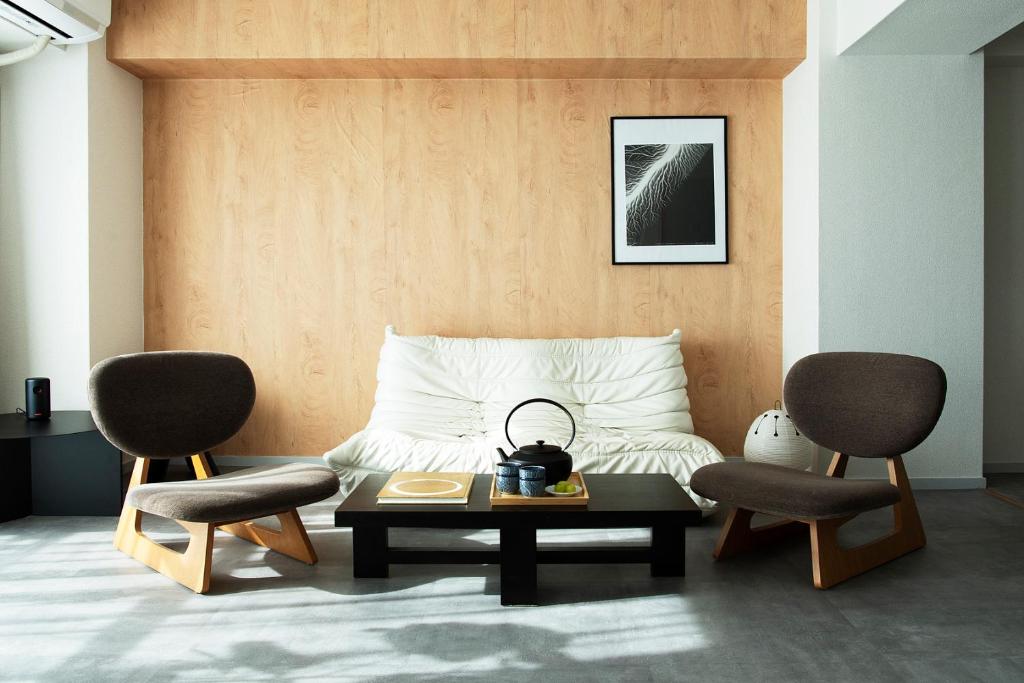 une chambre avec un lit avec deux chaises et une table dans l'établissement Zen apartment in central Tokyo, à Tokyo