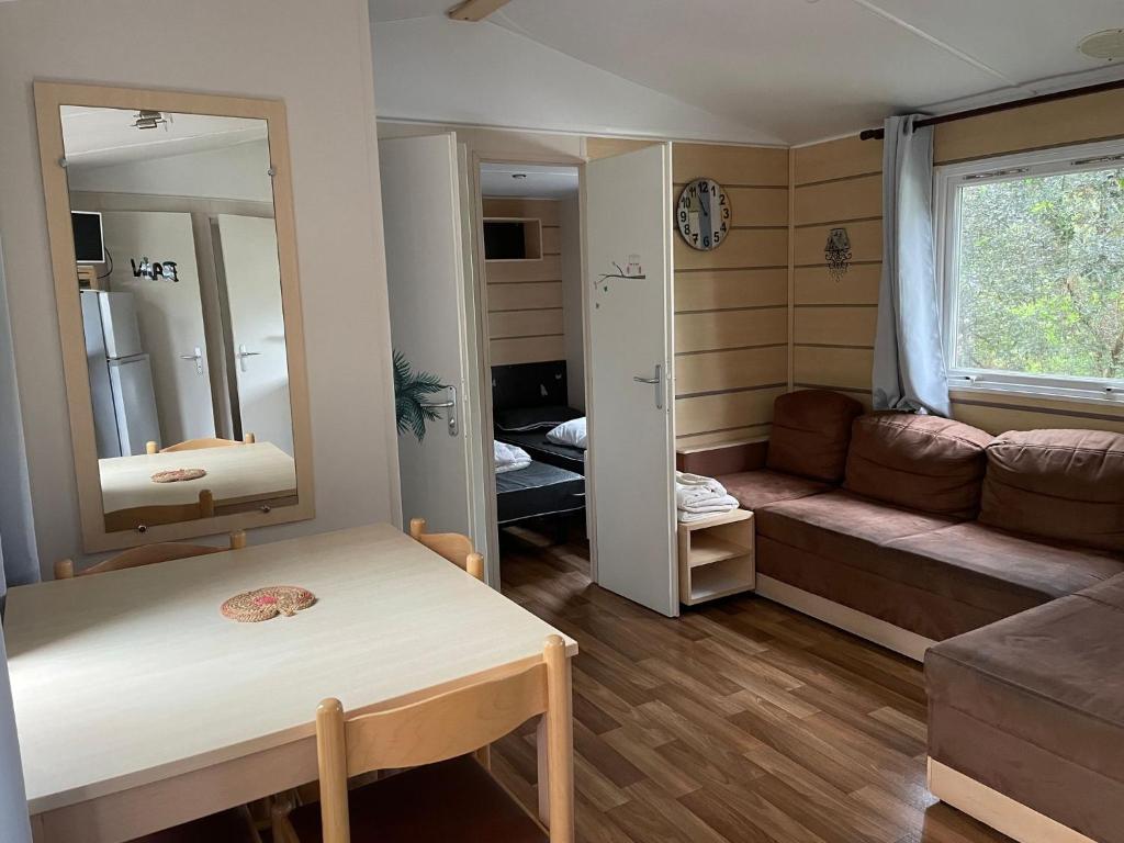 - un petit salon avec un canapé et un miroir dans l'établissement Mobile-home IRM Casita 3 Bedrooms - La Palmyre Bonne Anse Plage, aux Mathes