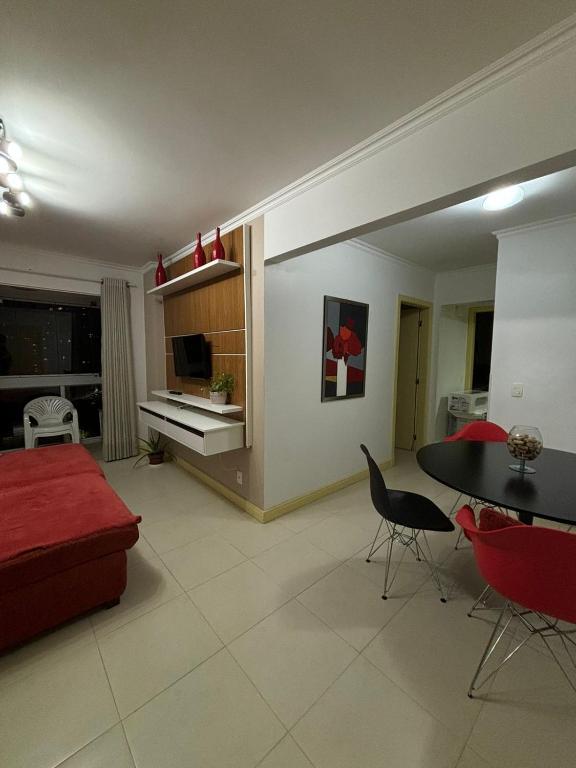 a living room with a red couch and a table at Apartamento quadra mar, 1 dos quartos com ar-condicionado , Barra Sul in Balneário Camboriú