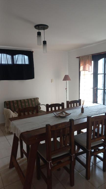 a dining room with a wooden table and chairs at Casa Quequen in Quequén