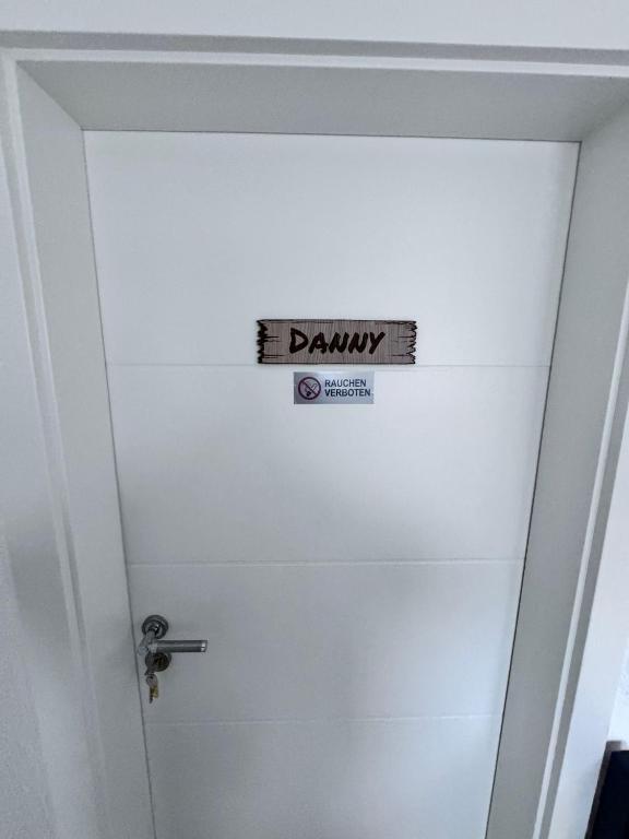 a white door with a sign on it at Ferienwohnung Danny in Marienheide