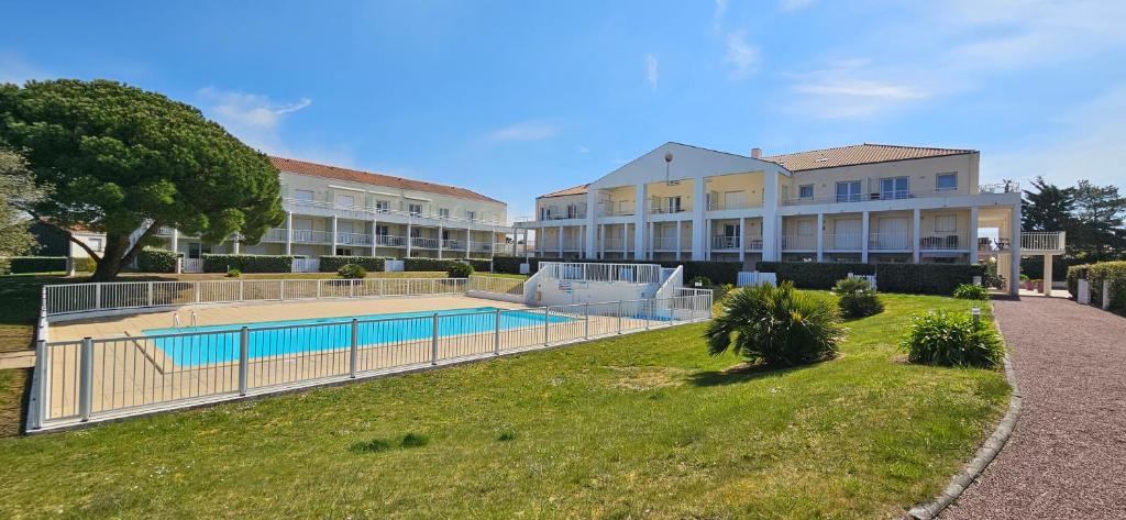 a large building with a swimming pool in a yard at L'Orchidée, 400m du lac & de la plage de Tanchet, 5 pers in Les Sables-dʼOlonne