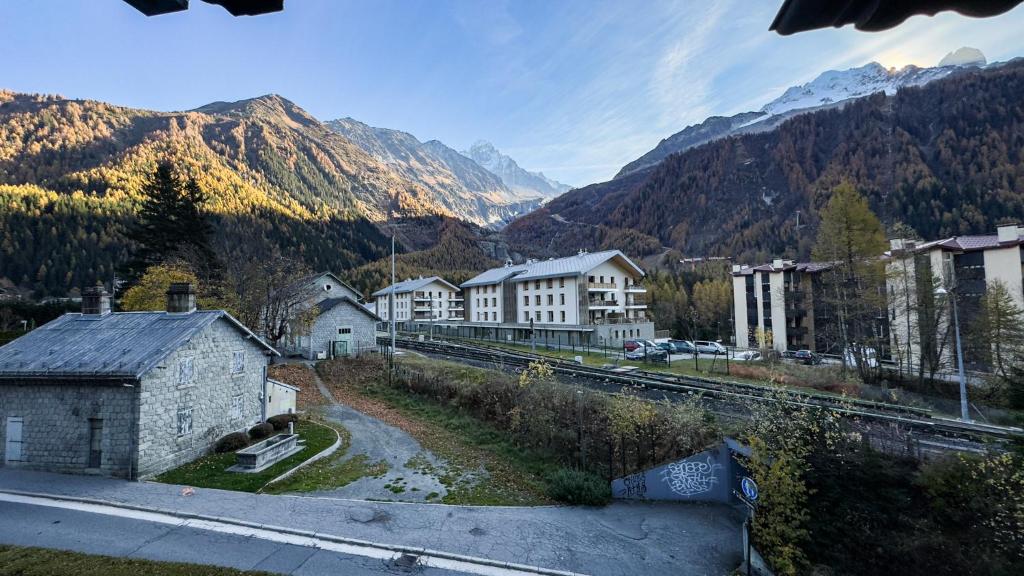 une ville avec une piste de train et des montagnes en arrière-plan dans l'établissement Appartement Avec Sauna, à Chamonix-Mont-Blanc