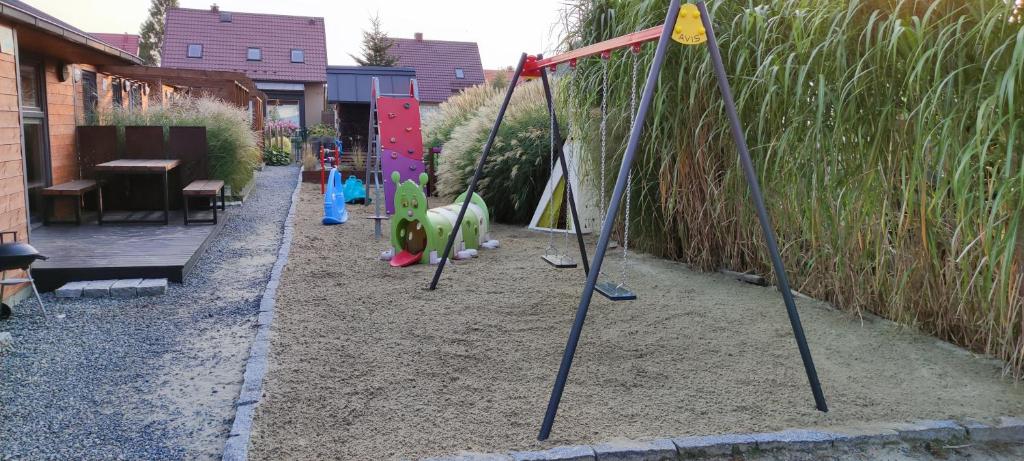 una fila di altalene in un parco giochi con erba alta di DOMKI WYPOCZYNKOWE ZOSIA I HELENKA a Puck
