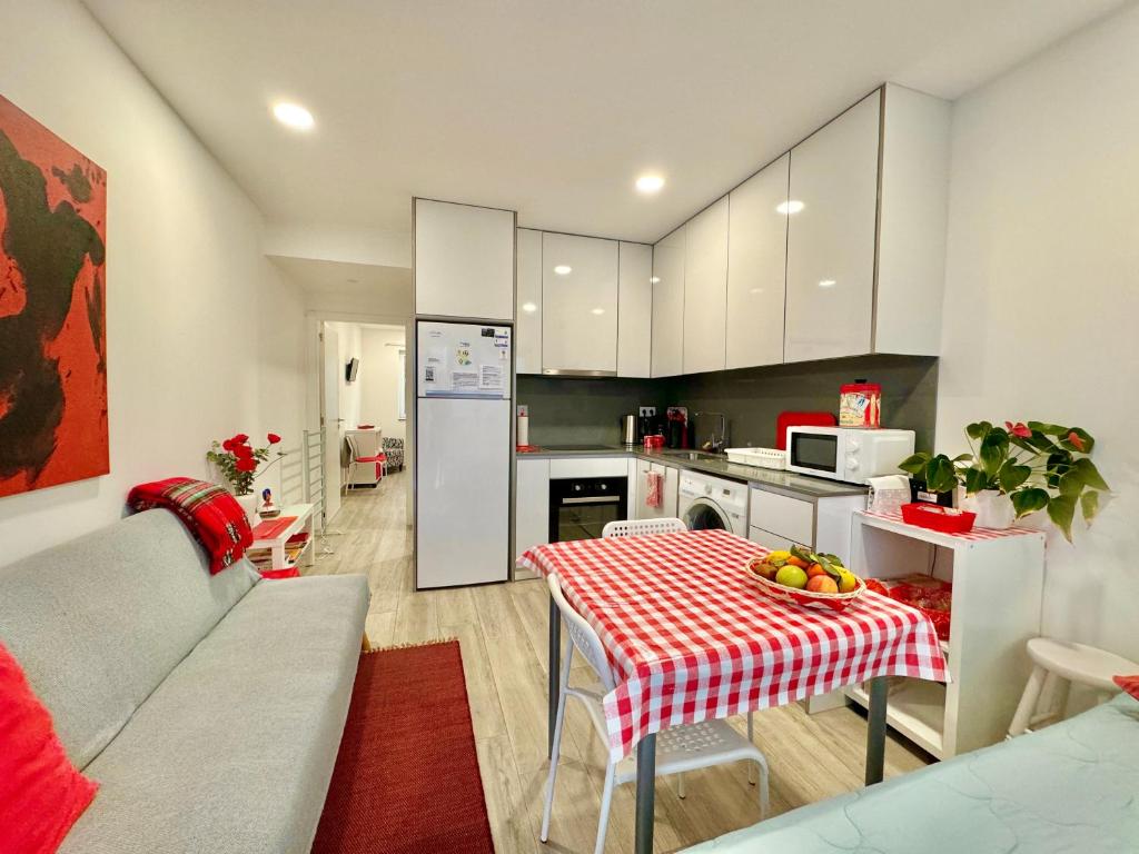 a kitchen with a table with a red and white table cloth at LOFT AS CASETAS PEREGRINOS in Rosal