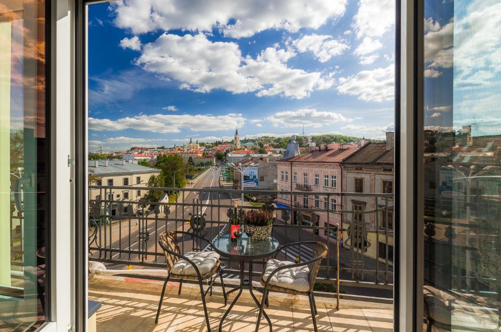 Un balcón con mesa y sillas y vista a una ciudad. en Panorama PREMIUM, en Przemyśl