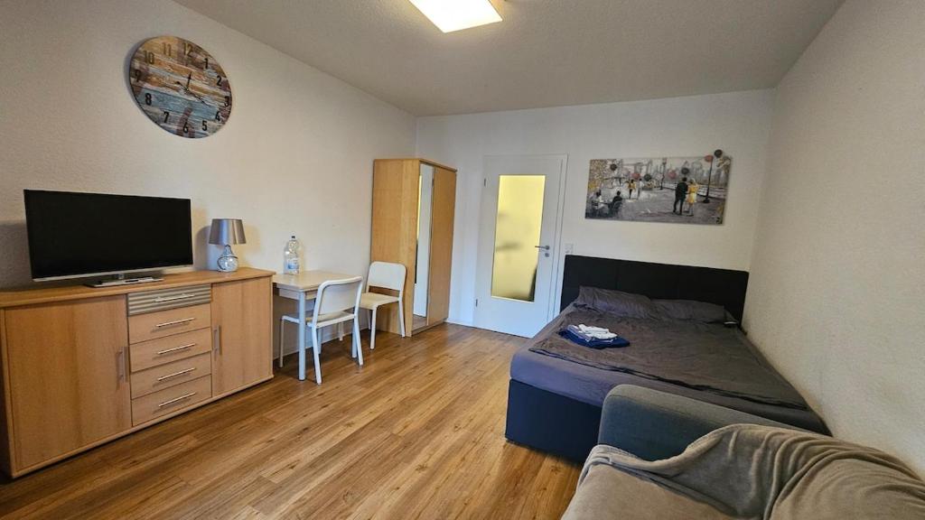 a bedroom with a bed and a desk with a television at Zentral gelegenes Apartment Nähe MHH und Eilenriede in Hannover