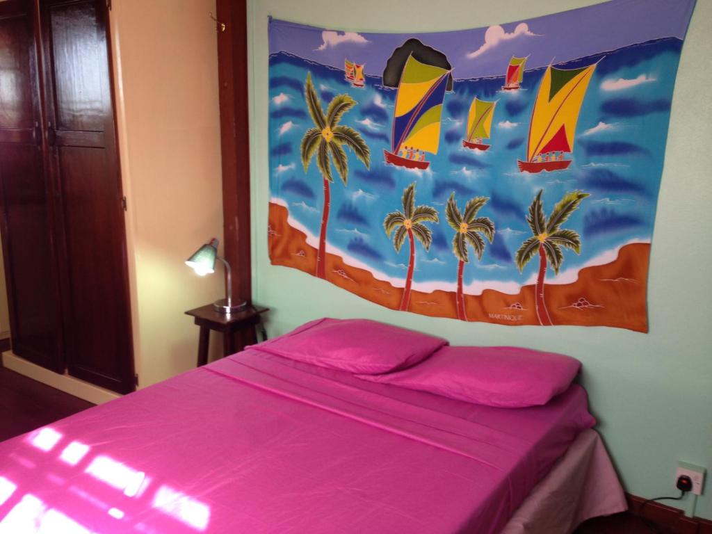 una camera con letto rosa e dipinto sul muro di Italian Guesthouse a Gros Islet
