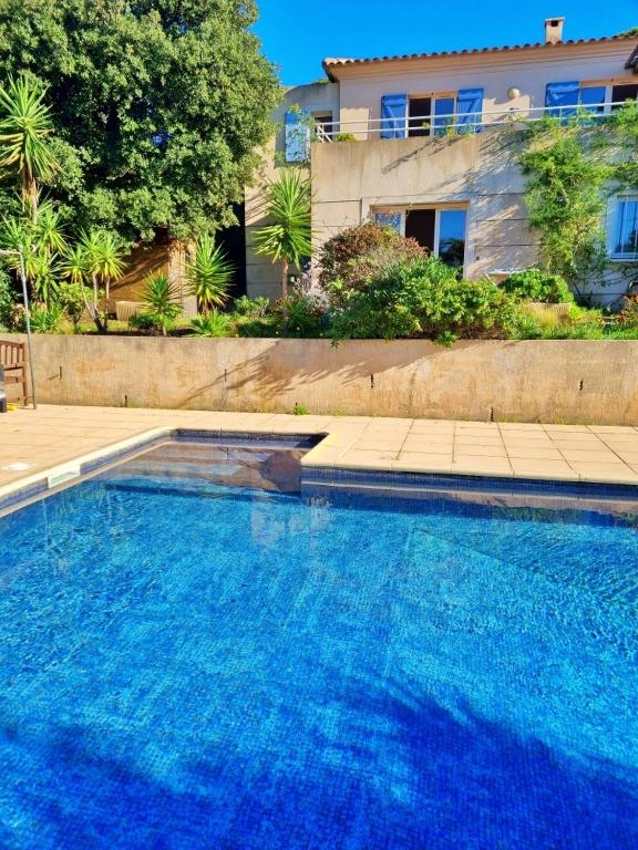 une grande piscine bleue devant une maison dans l'établissement Agréable 2 pièces dans villa avec piscine, à Calvi